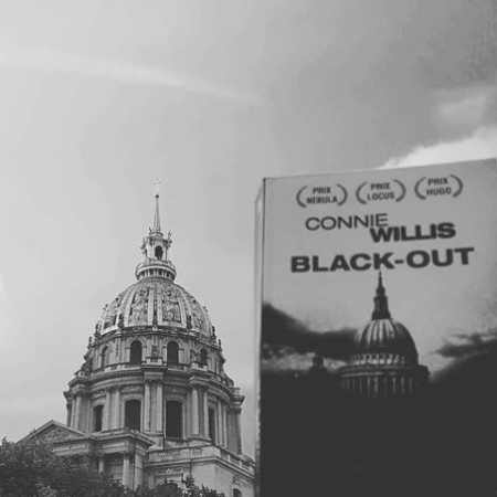 Photographie de la couverture du livre "Black out" de Connie Willis devant l'hôtel des Invalides à Paris. Le bâtiment sur la couverture du livre ressemblant beaucoup au dôme des Invalides.