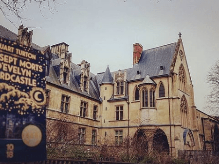 Photographie du livre "LEs sept mort d'Evelyn Hardcastle" de Stuart Turton prise dans le jardin du musée de Cluny pour le blog littéraire mangeurdelivres.wordpress.com