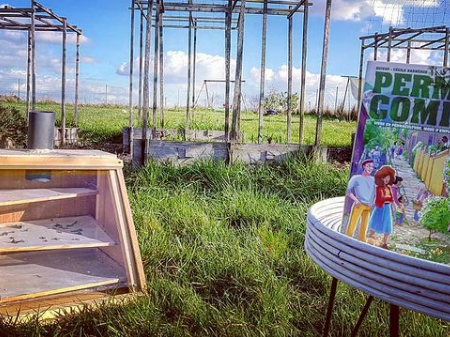 Photographie du livre "Permacomix" de Cécile Barneoud dans mon jardin à côté du séchoir solaire que j'ai construit moi même, pour le blog littéraire mangeurdelivres
