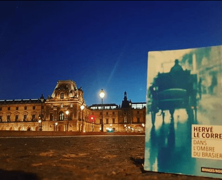 Photo du livre "dans l'ombre du brasier", d'Hervé Le Corre près du musée du Louvre à Paris pour le blog littéraire mangeurdelivres