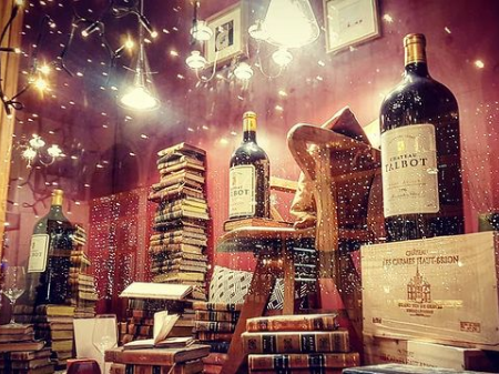 Vitrine située passage Jouffroy à Paris qui marrie des livres anciens et des grands crus de vins