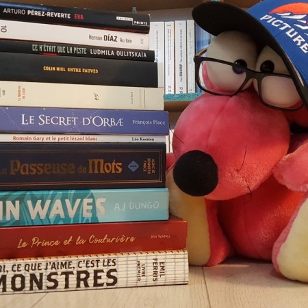 Pile de tous les livres que j'ai pu lire pendant le mois de mai 2021 à côté d'une peluche de souris rose à lunettes et casquette.